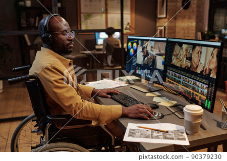 African professional editor with disability working with new content on computer at table at office till late evening African professional editor with disability working with new content on computer at table at office till late evening 90379230