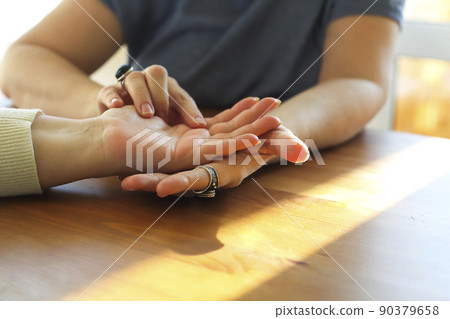 Woman visiting palmistry expert, fortune teller reading future, analyzing life lines on palm Woman visiting palmistry expert, fortune teller reading future, analyzing life lines on palm 90379658