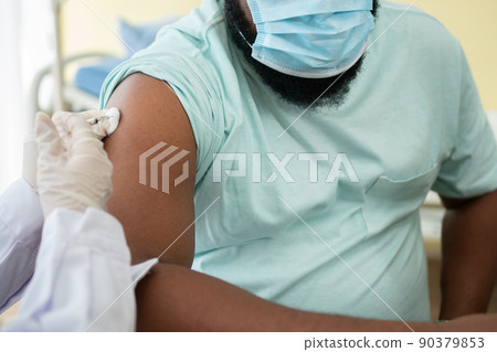 African American Wear a medical mask and being covid vaccinated for the prevention of coronavirus and flu. Concept of immunization from inoculation 90379853