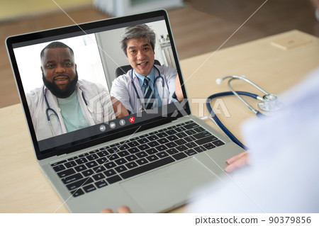 Screen application view of Asian senior doctor and African American wears white coat stethoscope on neck and video conference for discussion and sharing How to cure the virus. Concept of telemedicine 90379856