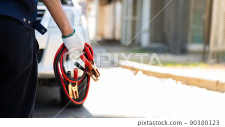 Focus car mechanic hand holding battery electricity cables jumper for charging car battery and repairing a broken car by connecting the battery, Services car engine machine concept Focus car mechanic hand holding battery electricity cables jumper for charging car battery and repairing a broken car by connecting the battery, Services car engine machine concept 90380123