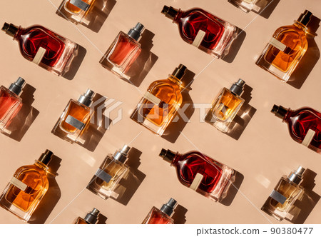 Pattern of different perfume bottles on a pastel beige background in the sunlight. Flat lay, top view. Luxury presentation mockup. Red, yellow and orange samples of aroma water Pattern of different perfume bottles on a pastel beige background in the sunlight. Flat lay, top view. Luxury presentation mockup. Red, yellow and orange samples of aroma water 90380477