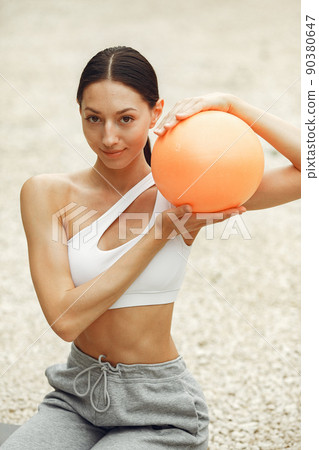 Pretty lady training on a summer beach. Brunette doing yoga. Girl in a sportsuit. Pretty lady training on a summer beach. Brunette doing yoga. Girl in a sportsuit. 90380647