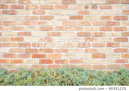 Brick wall and green of plants 90381228