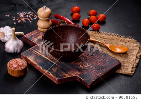 An empty plate with a knife, fork or spoon with a wooden cutting board An empty plate with a knife, fork or spoon with a wooden cutting board 90381555