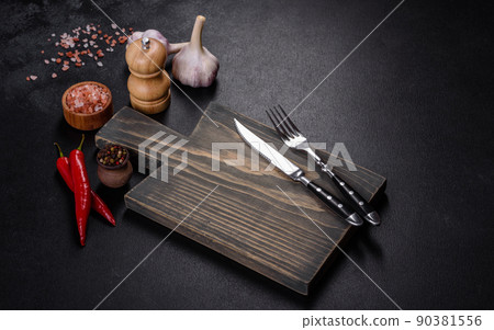 An empty plate with a knife, fork or spoon with a wooden cutting board 90381556