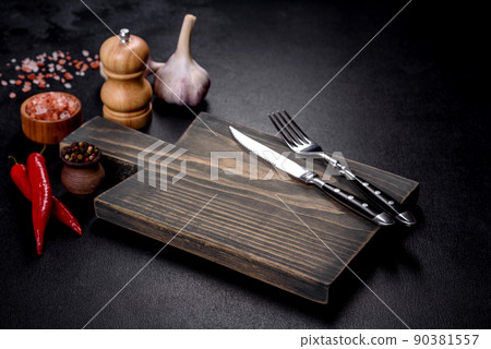 An empty plate with a knife, fork or spoon with a wooden cutting board 90381557