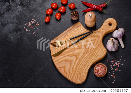 An empty plate with a knife, fork or spoon with a wooden cutting board An empty plate with a knife, fork or spoon with a wooden cutting board 90381567