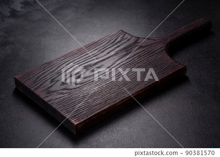An empty plate with a knife, fork or spoon with a wooden cutting board An empty plate with a knife, fork or spoon with a wooden cutting board 90381570