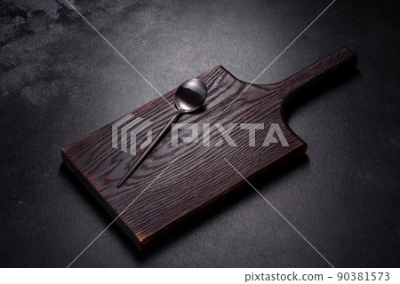 An empty plate with a knife, fork or spoon with a wooden cutting board An empty plate with a knife, fork or spoon with a wooden cutting board 90381573