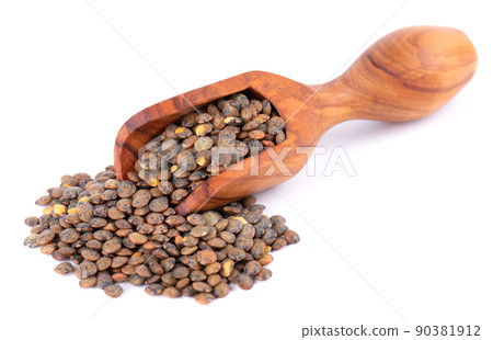 French lentils in olive spoon, isolated on white background. Dry puy lentil grains pile. 90381912