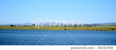 Panoramic view of Lake Shabania in the Golan Heights overlooking a green plain and a mountain range in the distance. Panoramic view of Lake Shabania in the Golan Heights overlooking a green plain and a mountain range in the distance. 90382906