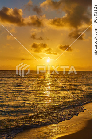 Golden hour of sunset with sandy beach and waves of ocean water Golden hour of sunset with sandy beach and waves of ocean water 90383128