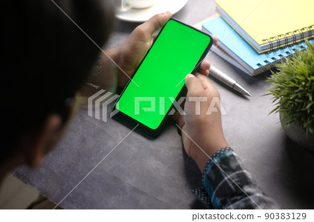 top view of man hand using smart phone on office desk top view of man hand using smart phone on office desk 90383129