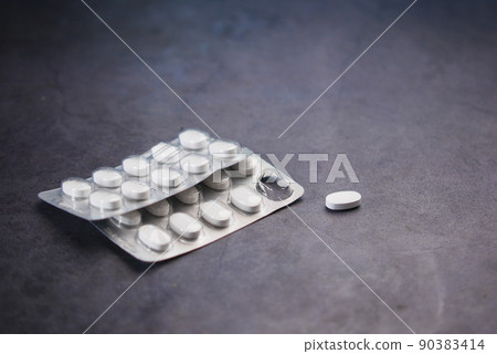 Close up of pills of blister pack on black background Close up of pills of blister pack on black background 90383414