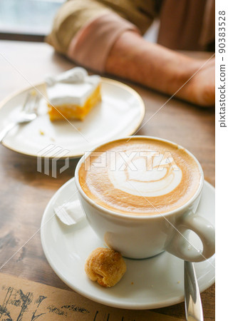 a cup of late coffee with flower shape design on top at cafe  90383528