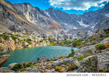 Large lake tucked into mountains with snow 90383631