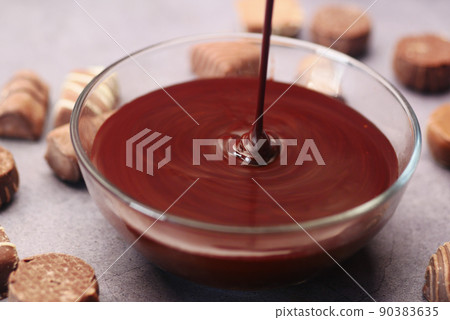 dark chocolate cream pouring in a bowl on table  90383635