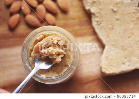 almond butter spread on a brown bread on table almond butter spread on a brown bread on table 90383714
