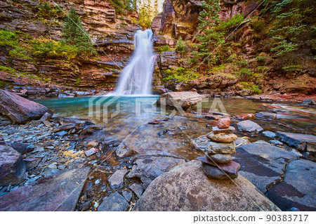 Cairn stack of stones next to hidden secret waterfall tucked into gorge Cairn stack of stones next to hidden secret waterfall tucked into gorge 90383717