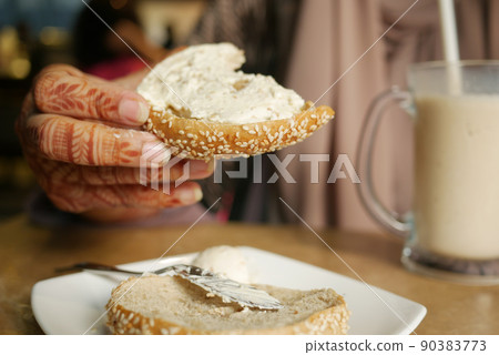 cheese cream spread on fresh bagel bread  90383773