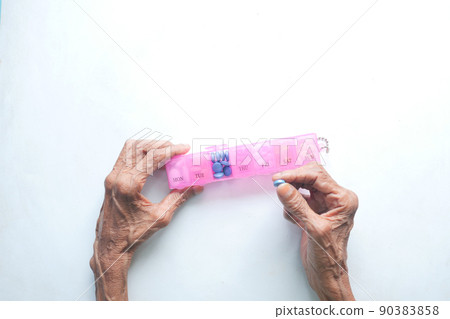 top view of senior women hands taking medicine from a pill box top view of senior women hands taking medicine from a pill box 90383858