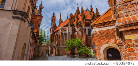 Vilnius, Lithuania. Roman Catholic Church Of St. Anne And Church Of St. Francis And St. Bernard In Old Town In Summer Sunny Day. UNESCO World Heritage Vilnius, Lithuania. Roman Catholic Church Of St. Anne And Church Of St. Francis And St. Bernard In Old Town In Summer Sunny Day. UNESCO World Heritage 90384072