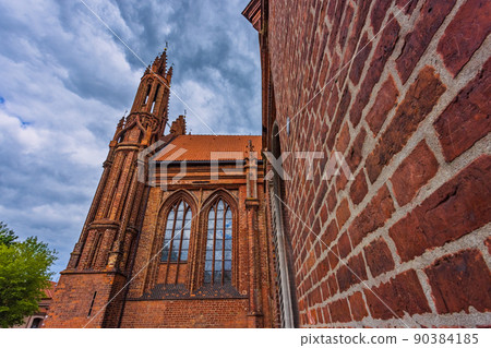 Vilnius, Lithuania. Roman Catholic Church Of St. Anne And Church Of St. Francis And St. Bernard In Old Town In Summer Sunny Day. UNESCO World Heritage Vilnius, Lithuania. Roman Catholic Church Of St. Anne And Church Of St. Francis And St. Bernard In Old Town In Summer Sunny Day. UNESCO World Heritage 90384185