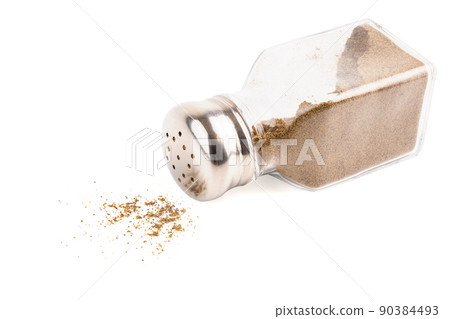 glass pepper pot with ground black pepper dropped on its side isolated on white background 90384493