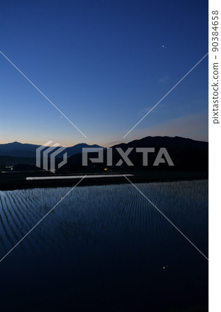 木星和火星在北斗市白州町稻田的映照下,在黎明的天空中排成一列。金星升得很晚。 木星和火星在北斗市白州町稻田的映照下,在黎明的天空中排成一列。金星升得很晚。 90384658