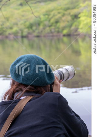 A person taking a picture by the lake 90384988