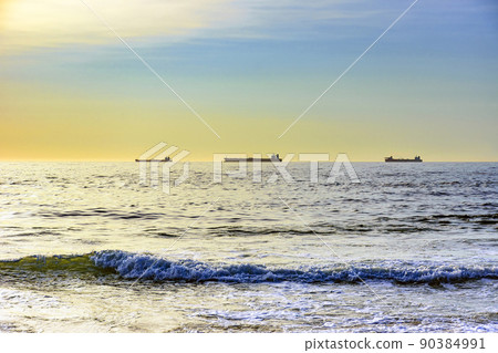 Ships moored on the horizon during dawn on Ipanema beach Ships moored on the horizon during dawn on Ipanema beach 90384991