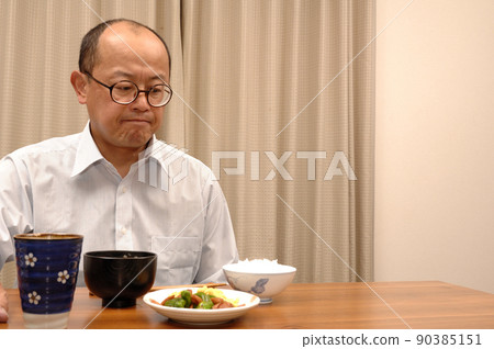 Middle-aged man eating at home Middle-aged man eating at home 90385151