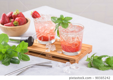 Cold summer strawberry iced cocktail mojito, margarita, daiquiri in two glasses with mint leaves on light background Cold summer strawberry iced cocktail mojito, margarita, daiquiri in two glasses with mint leaves on light background 90385242