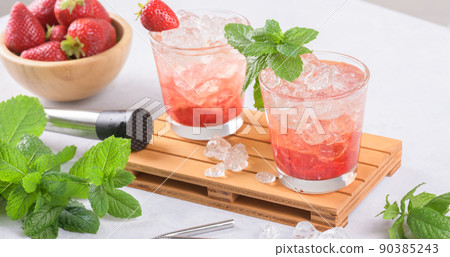 Cold summer strawberry iced cocktail mojito, margarita, daiquiri in two glasses with mint leaves on light background Cold summer strawberry iced cocktail mojito, margarita, daiquiri in two glasses with mint leaves on light background 90385243