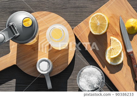 Cooking fresh homemade isotonic from natural ingredients - salt, lemon and mineral water. Top view, flat lay, selective focus Cooking fresh homemade isotonic from natural ingredients - salt, lemon and mineral water. Top view, flat lay, selective focus 90386233