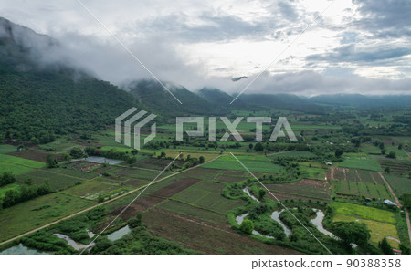 high aerial farm view with mountain from drone flying over after raining in season 90388358