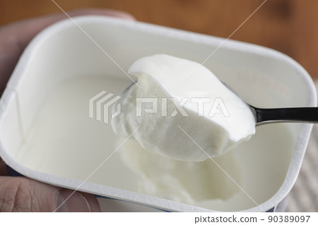 用勺子將原味酸奶舀入包裝容器中,然後食用 用勺子將原味酸奶舀入包裝容器中,然後食用 90389097