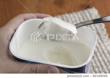 用勺子將原味酸奶舀入包裝容器中,然後食用 用勺子將原味酸奶舀入包裝容器中,然後食用 90389099