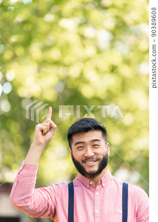 Chinese man in casual clothes pointing to the sky 90389608