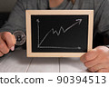 A woman holding a gold bitcoin and a board with a graph. Cryptocurrency. 90394513
