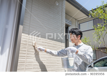 Painter painting the walls of a detached house Painter painting the walls of a detached house 90395956