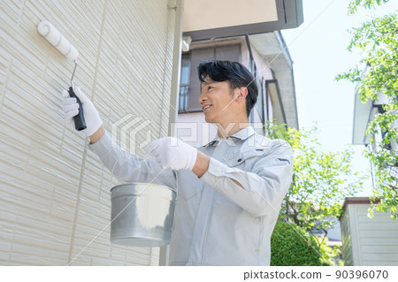 Painter painting the walls of a detached house 90396070