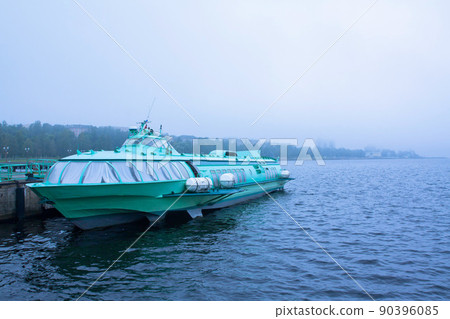 Passenger hydrofoil boat on the docks of Onego lake in foggy weather, Petrozavodsk, Karelia, Russia. 90396085