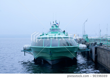 Passenger hydrofoil boat on the docks of Onego lake in foggy weather, Petrozavodsk, Karelia, Russia. Passenger hydrofoil boat on the docks of Onego lake in foggy weather, Petrozavodsk, Karelia, Russia. 90396089