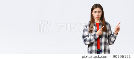 Lifestyle, different emotions, leisure activities concept. Gloomy cute girlfriend or daughter begging for something, pointing finger right with sulking face, express regret, wishing have this thing 90396131