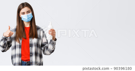 Coronavirus outbreak, leisure on quarantine, social distancing and emotions concept. Satisfied female customer, shop client in medical mask advice this hand soap or hand sanitizer, thumb-up 90396180