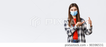 Coronavirus outbreak, leisure on quarantine, social distancing and emotions concept. Young woman taking care of health, preventing virus measures, apply soap or hand sanitizer, wear medical mask 90396531