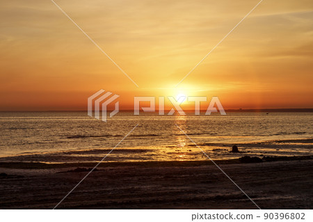 Beautiful sunset over the sea. The sun sets on the water. The sky is painted with golden bright colors. Summer evening. Sunset beach. Beautiful sunset over the sea. The sun sets on the water. The sky is painted with golden bright colors. Summer evening. Sunset beach. 90396802