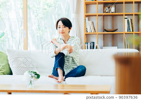 A middle-aged woman relaxing in the living room 90397636